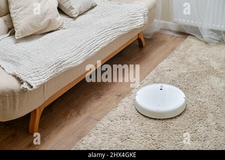 White robot cleaner Xiaomi Mi Vacuum-Mop on a fleecy carpet, home interior - Moscow, Russia, March 05, 2022 Stock Photo