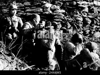 Capture of Yi Kiang Shan - Chinese "Liberation Army" troops stormed and captured the nationalist held island of Yi Kiang Shan, one of the Tachen group, on Jan 18 in a sudden assault supported by naval and air forces. According to Communist sources in Peiping this nationalist soldiers leaving one of their bunkers after the Island surrendered. A Chinese Communist soldier covers them at pistol point. March 23, 1955. Stock Photo