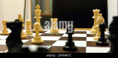 White and black chess pieces on a chess board during a chess game. Stock Photo