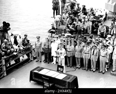 Surrender In Tokyo Bay: General Sir Douglas MacArthur at the microphone making the speech that opened proceedings at the signing of the surrender documents on hoard USS 'Missouri' in Tokyo Bay, while lined up behind him are the signatories for the Allied Nations. January 1, 1945. (Photo by Australian Official Photo). Stock Photo