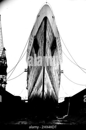 The Queen Mary Is Also Held Up -- A bow view of the Queen Mary in dry dock at Southampton. Whilst her sister-ship the Queen Elizabeth is prevented from sailing by the strike dispute at Southampton, the R.M.S. Queen Mary is also held up. She should have taken over the Elizabeth's berth on Saturday. Meanwhile, she is being kept in the King George V Grading Dock, where for over a week more than 800 workmen have been engaged on preparing her for a resumption of her dollar-earning transatlantic voyages. November 22, 1948. (Photo by Fox). Stock Photo