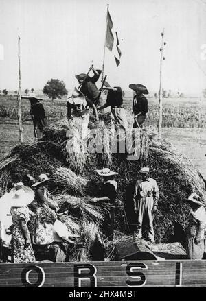 Mussolini As Harvester -- Signor Mussolini both addressed the ***** and worked with them at the first harvest ***** reclaimed pointe marshes near Rome. He ***** worked at threshing for three hours ***** received his wage with the other labour *****. Mussolini may be seen in ***** at work with a threshing machine. August 21, 1934. (Photo by Sport and General Press Agency, Limited). Stock Photo