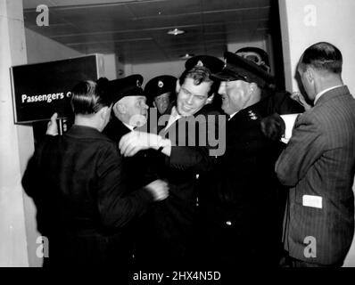 Johnny Ray Gets Mobbed - Again -- Getting mobbed by hysterical fans (mainly women) is no new experience for American singer Johnny Ray. Police had to patrol the London Palladium for over three hours during his farewell performance there on Saturday evening and in Edinburgh the following day he was again set upon by admirers who ***** him into his hotel. When this picture was taken Johnny was just getting away from some more fans at London Airport with the aid of police and airport officials. May 9, 1955. (Photo by Daily Express Picture). Stock Photo