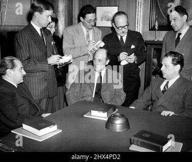 Hungarians Hold Press Conference -- Laszlo Acsay, Alexander Szasz, former counsellor of the Hungarian legation, and Zoltan Pfeiffer, leader of the Hungarian independent party who recently fled from his communist-controlled country, (left to right seated) hold a press conference in Washington, D.C., Nov .14. Standing behind Pfeiffer is Aladar Szegedy-Maszak, former Hungarian minister to the United States. November 16, 1947. (Photo by Associated Press Photo). Stock Photo