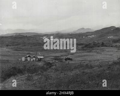 Fiji Gold Mines -- Loloma West where drilling operations are in progress and the ore being tested at various depths. In the distance is the Emperor mine. The offices of the Emperor mine are on top of the hill. The buildings to the right are connected with Loloma the shaft of which is not in this photo. October 27, 1935. (Photo by W. H. Raine). Stock Photo