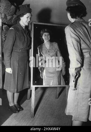 Pleased with her Reflection - In new tropical dress, just issued for use in the far east only, 21-year-old Irene Evans Admires her looks while Doreen Brown holds the mirror for her. The new 'issue' is a one-piece linen tailored dress. The picture was taken to-day at the women's Royal Army Corps Depot, Guildford, Surrey, from where the girls later left for Southampton. They will Embark to-morrow in the 'Empire Windrush' for the far east. January 16, 1952. (Photo by Paul Popper, Paul Popper Ltd.). Stock Photo