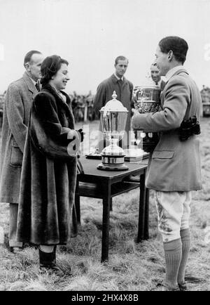 Queen Presents Point-To-Point Trophies -- Queen Elizabeth presenting the Prince of Wales cup to Mr. A. J. White, who won on 'Idle Wild' at the United Services point-to-point steeplechases here. The Queen and the Duke of Edinburgh, who are the weekend guests of the Earl and countess of Pembroke at 'Wilton', attended the meeting. February 22, 1953. Stock Photo