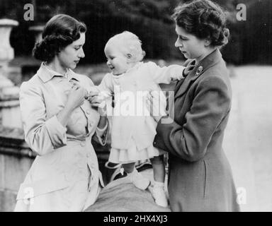 The Royal Family At Balmoral : A charming study of the Royal sisters taken during one of these happy family gatherings. It shows Princess Elizabeth (right) and Princess Margaret help balance baby Princess Anne on a balustrade in the castle grounds. Like all babies, Princess Anne loves sparkling things and plays delightedly with Princess Margaret's brooch. The King and Queen and Princess Margaret who are in residence at Balmoral Castle, Scotland, are being paid frequent visits by Princess Elizabeth and the Duke of Edinburgh, staying at nearby Birkhall. Royal approval has been given for the publ Stock Photo