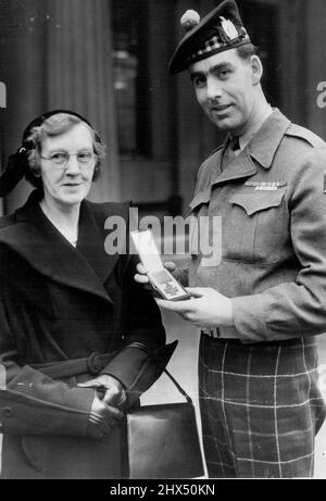 Proudest Mother of All Speakman Presented With V.C. At Palace -- A proud Bill Speakman of the Black Watch shows his mother the Victoria Cross presented to him when the Queen held her first Investiture at Buckingham Palace to-day. The 24-year-old solider of Altrincham, Cheshire, won the decoration in Korea. February 27, 1952. Stock Photo