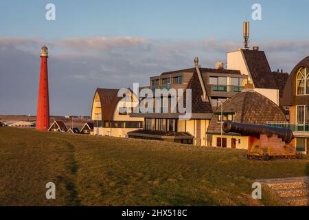 Red Lighthouse named Lange Jaap and an old cannon seen from the dike at dutch village Huisduinen, Province North Holland Stock Photo