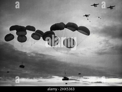 'Part Time: Parachutist in Arnhem Day Exercise - Jeeps and other heavy equipment being parachuted from the C119 American aircraft over the Stanford (Norfolk) practical training area, during the T.A. airborne exercise which took place yesterday - the anniversary of Arnhem.1,200 Territorials yesterday parachuted down upon their 'enemy' in Norfolk, during exercise 'King's Joker' the  biggest peacetime airborne exercise ever  held by the T.A. The men and their equipment dropped from a height of 800 feet from a fleet of American aircraft flown from Germany to Lakenheath air station. September 18, 1 Stock Photo