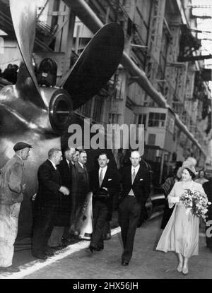 Queen Tours Shipyard Before 'Ark Royal' Launch -- The Queen passes a ship's propeller as she walks through the Cammell Laird yards to the launching platform to-day. The Queen launched the new 'Ark Royal', Britain's most powerful aircraft carrier, from the Birkenhead (Cheshire) yards of Cammell, Laird to-day (Wednesday). Watching from grandstand seats were officers and men of the old 'Ark Royal', the gallant carrier so often 'Sunk' by Dr. Goebbels, that finally met her end in the Mediterranean in 1941. May 03, 1950. (Photo by Reuterphoto). Stock Photo