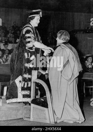 Queen Mother Confers Honorary Degree on Mrs. Pandit -- Queen Elizabeth the Queen Mother, who had just been installed as Chancellor of London University, confers the honorary degree of Doctor of Laws on Mrs. Vijaya Lakshmi Pandit, India's High Commissioner in London, at the Royal Festival Hall, London, to-day (Thursday). The Conferment of honorary degrees on Mrs. Pandit and a number of other distinguished persons followed the installation ceremony. November 24, 1955. (Photo by Reuterphoto). Stock Photo