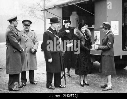 King and Queen Inspect Mobile Tea Car - The Queen being shown part of the mobile tea car's equipment by Lady Blane (in Y.M.C.A. uniform) while the King (on left) chats with Major-General Sir John Brown. The King and Queen inspected a Y.M.C.A. mobile tea-car unit for the troops in the grounds of Buckingham Palace today (Friday) before its departure for France. The tea-car inspected by their Majesties was one raised by auction by the Lord Mayor of London, at the Tea Exchange. March 11, 1940. (Photo by London News Agency Photos Ltd.). Stock Photo
