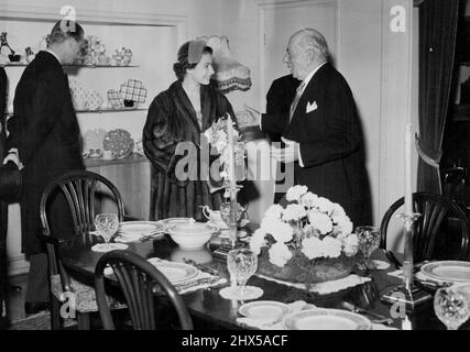 Queen Begins Herr 3-County Tour of the Midlands -- The Queen smiles her thanks as she is presented with a lovely Dinner Service by Sir Ernest Johnson, Chairman of Messrs. Johnson Bros. (Hanley) Ltd. a well-known Stoke-on-Trent Potteries, during her visit there this afternoon with H.R.H. The Duke of Edinburgh, who can be seen in the background inspecting items on show. H.N. The Queen and H.R.H. The Duke of Edinburgh today began their two-day tour of the Midlands, which extends into three counties. During their heavy 13-hour programme today, they visited Nantwich, Crewe, Newcastle-under-Lyme, th Stock Photo