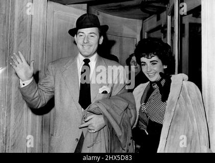 Michael and Elizabeth Leave For Honeymoon -- Screen actor Michael Wilding, aged 39, with his actress-bride Elizabeth Taylor, aged 19, leaving their London hotel for London airport. They are flying to Paris for their honeymoon following their marriage yesterday (Thursday) at Caxton Hall, London. February 22, 1952. (Photo by Planet News) Stock Photo