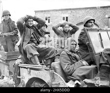 American Soldiers Bring in Nazi Intelligence Patrol U.S. soldiers of the Second Armored Division bring in three Nazis, members of an intelligence patrol, after capturing them on the outskirts of a Belgian town. The two Nazis riding in the roar of the U.S. Army vehicle have their hands on their heads; the prisoner in front has apparently suffered a head injury. Between December 16, 1944, when the enemy launched their counter-offensive on the 'estern Front, and January 3, 1945, it was officially estimated by the Allies that the enemy had suffered 60,000 casualties, including prisoners. At least Stock Photo