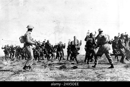 Italians Surrender to British in Tunisia. Their hands up raised, a group of Italian soldiers surrender to Tommy-Gun carrying Eighth Army during the British drive northward in Tunisia **** his group was said to have been ***** 20,000 prisoners captured ***** Army between March 20 and April 12. May 17, 1943. Stock Photo