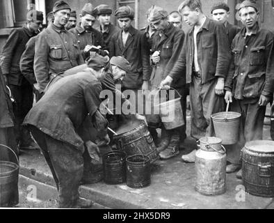 Americans Liberate Allied soldiers Imprisoned By Nazis In France - Newly liberated Russian soldiers waiting for soup, mado by their own cooks from U.S. supplies. When the Third U.S. Army, commanded by Lieutenant General George S. Patton, Jr., liberated Saarguemines, France, December 12, 1944, they found a German prisoner-of-war camp where Russian, Serbian, Polish and Italian soldiers were incarcerated, Conditions were appalling. Men were quartered in rooms of seven by eight feet. Few had stoves in them. Three tier bunks were used. Each prisoner had only one no sanitary facilitations whatever. Stock Photo