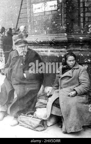 German Displaced Persons Wait For Trains - A study of two aged German displaced persons who waited with their baggages outside the Anhalter Banhof station, Berlin, October 11 for the train to Wittenberg. The removal of displaced persons is one of the many unsolved problems in Berlin. on October 11, Hundreds of these displaced persons in Berlin for a train to Wittenberg, Germany, Enroute home. Many of them had waited as long as two days for the next one. October 14, 1945. (Photo by Associated Press Photo). Stock Photo