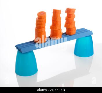 Stacks of chopped carrots balanced on plastic cups, close-up Stock Photo