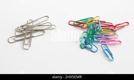 Plain silver and colourful paper clips, close-up Stock Photo