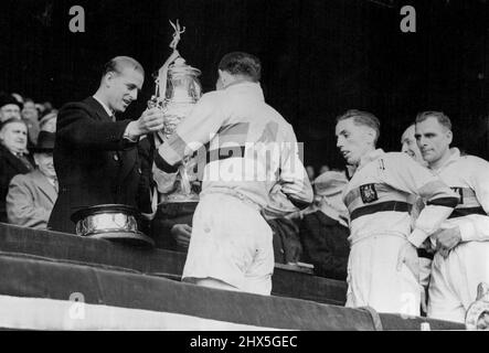 The Duke Presents Cup to Rugby Cup Final Winners -- The Duke of Edinburgh is seen presenting the Rugby League Cup to E. Ward, captain of Bradford Northern who defeated Halifax at Wembley this afternoon. May 7, 1949. (Photo by Reuterphoto). Stock Photo