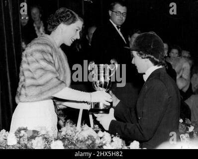 Queen 1955 Sees Italy Win Coveted Show Jumping Prize. The Queen presenting the Queen Elizabeth II cup to miss dawn Palethorpe... at the White City last night. For the first time since 1939, Italy has won the King George V gold challenge cup coveted prize in the International horse show men's jumping championship. The Italian horseman, Lt. Col. Cartasegne, riding Brando, won the cup at the White City last night. July 21, 1955. (Photo by Paul Popper Ltd.). Stock Photo