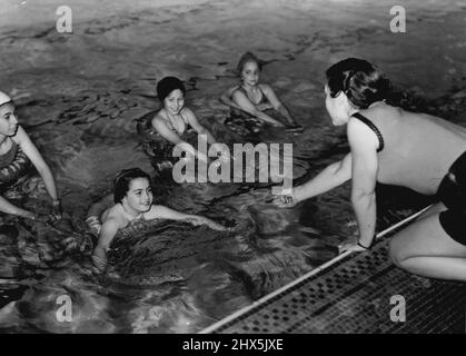 Soho School Lifts Babel's Curse All Soul's School, London. Swimming classes in the Marshall street swimming baths. Left to right: Sybil Jacobvitch; Androulla Savva (Cypriot); Mary coutsarou (Cypriot); Betty Healey. June 01, 1952. (Photo by Central Office of Information Photograph). Stock Photo