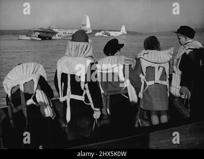 Flying Boat; Take Out Berlin Children -- Berlin kiddies, wearing life-jackets, look with keen interest towards the royal air force flying-boats moored on Berlin's Havel Lake, November 25. The children were about to go aboard the aircraft to be flown to Hamburg in the British zone of Germany, where they will remain until the blockade of Berlin is lifted. Some 400 children a day are being flown out to better conditions in bring air-lift supplies into the German Capital, fly the children out. December 02, 1948. (Photo by Associated Press Photo). Stock Photo