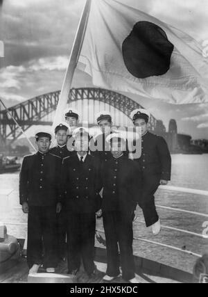 Cadets on board the Japanese training ship Taisei Maru which arrived in Sydney for a six days visit look over the harbour from the Stern of their ship. With them is their instructor 2nd Officer Tatsumi Tokuda. August 04, 1955. (Photo by Alec Iverson/Fairfax Media). Stock Photo