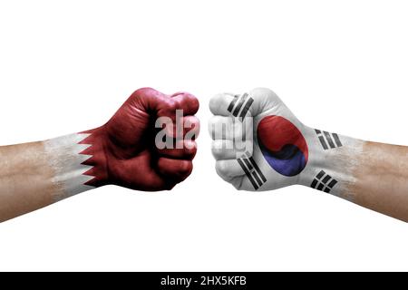 Two hands punch to each others on white background. Country flags painted fists, conflict crisis concept between qatar and south korea Stock Photo