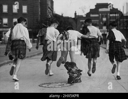 Sassenachs, Now You Know -- Here, at last, is the truth. A boy forgets to fasten all his kilt pins - and Sassenachs get to the bottom of the question which has puzzled them ever since Scotsmen took to skirts. These boys were taking part in a display of folk dancing, organised by the Council of Social Service, at an L.C.C. housing estate in Percival-street London. June 19, 1950. (Photo by Daily Mirror). Stock Photo