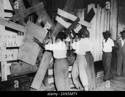 Indians board-up shops after racial riots in Africa. Indians nailing up boards over the front of shops after they had been battered by natives during the recent racial riots in this South African city (capital of Natal) which had spread from Durban where flare-up began. January 24, 1949. Stock Photo