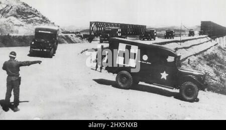 Practice Run Over Freedom Gate Bridge -- United Nations ambulances in a practice run over Freedom Gate bridge (upper right) are directed by MP on south side of the Imjin river. This is another rehearsal project in the vicinity of Panmunjom Korea, for the forthcoming transfer of sick and wounded Pows, termed 'operation little Switch'. April 14, 1953. (Photo by AP Wirephoto). Stock Photo