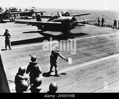 Battle Stations Aboard - A U.S. Aircraft Carrier -- Steaming through the waters of the Pacific Ocean, 'somewhere in a battle zone,' a U.S. Navy aircraft carrier launches its fighter aircraft. The signal 'Battle Stations' has brought gunners to the anti-aircraft guns; the officers on the signal bridge and in plotting rooms work out technical information; Marines jump to their post; planes are warmed up on the flight deck. This series of pictures, taken during a battle in the Pacific, shows the me Stock Photo