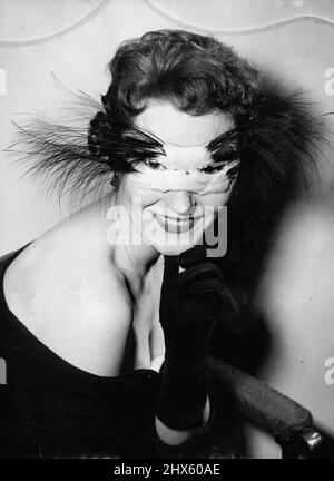 Christmas Mystery -- Apt for a midnight reveller is this cat mask, modelled by Jenny Gayton of Renfrew, for the Midnight Fashion Parade to be stage at the Hungaria Restaurant in Lower Regent Street, London, to-night (Thursday). White feathers form the mask and the whiskers are black osprey. This cat mask, worn by Jenny Gayton, was modelled for Christmas Eve revels in England. It was shown at a midnight fashion parade in London. December 10, 1953. (Photo by Reuterphoto).;Christmas Mystery -- Apt Stock Photo