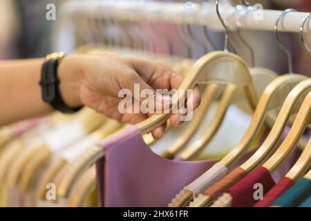 Clothes that are arranged on shelves and hangers. Stock Photo