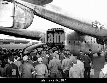 'Flying Boxcar' Takes Cars From Berlin. An American car from Blookaded Berlin is loaded into a United States Air Force 'Flying Boxcar' (C-81) at Tempelhof Airport, September 14. The aircraft is the first of its kind to be introduced on the Berlin 'Air-Life' and the car is the first of many American-owned vehicles that are to be flown out of the German capital. September 16, 1948. (Photo by Associated Press Photo). Stock Photo