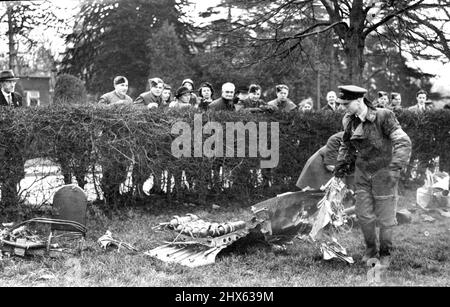 Germans Lose Nine Planes in Reprisal Raid on The London Area. R.A.F. officers examining the wreckage of a JU.88 which was brought down and finally crashed in a recreation ground, narrowly missing some houses, on the outskirts of London. For the first time since May 1941, German planes raided the London area as a 'reprisal' for the R.A.F. heavy blitz on Berlin. Nine of the raiders were destroyed during the attack Bomb damage was hot heavy. January 18, 1943. Stock Photo