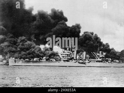 Light Cruiser Passes Burning U.S.S. Arizona -- A light cruiser, undamaged, steams out past the burning U.S.S. Arizona and takes to sea with the rest of the fleet, during the Japanese aerial attack on Pearl Harbor, Hawaii December 7. February 2, 1942. (Photo by Associated Press Photo). Stock Photo