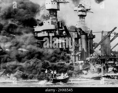 A small boat rescues seamen from the 800 U.S.S. West Virginia burning in the foreground. Smoke rolling out amidships shows where the most extensive damage occurred. Note the two men in the superstructure. The U.S.S. Tennessee is inboard. January 20, 1943. (Photo by Fox Photos). Stock Photo