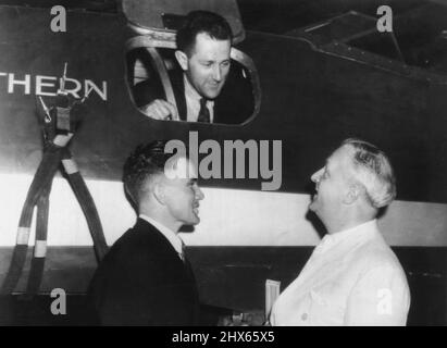 Preparing For London-Sydney Hop -- Re-assembling the trans-pacific 'Southern Cross' for a 11,300 mile hop from London to Sydney, as they await the arrival of Sir Charles Kingsford-Smith, noted Australian flyer, are, top, Robert Bolton, Chief Engineer, Thomas Pethybridge, left, co-pilot on the proposed flight and P.G.B. Morriss, the pilot's personal representative. September 2, 1935. (Photo by Associated Press Wirephoto). Stock Photo