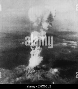 First Atomic Bomb Bursts On Japan -- A tall column of smoke billows 20,000 feet above Hiroshima, Japan, after the tirst atomic bomb strike by Auerican air forces on August 6. A cloud of smoke 10,000 feet in diameter covers a part of the city at base of column. This picture was made after the bomb was released from an altitude of between 20,000 and 30,000 feet. August 11, 1945. (Photo by AP Wirephoto). Stock Photo