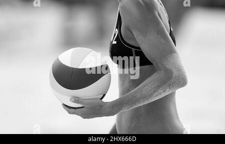 A Female Beach Volleyball Player Is Getting Ready To Serve The Ball In Black And White Image Format Stock Photo