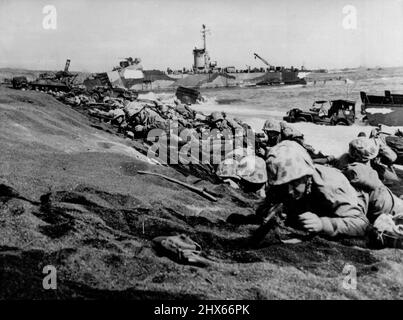 Pinned Down -- Fourth Division Marines are pinned down by enemy fire as they hit the 'beach at Iwo Jima on D-Day, February 19. Making their fourth amphibious assault in 13 months, the veteran fighters are ready to secure the right flank of the initial beachhead. March 14, 1945. (Photo by Official U.S. Marine Corps Photo). Stock Photo