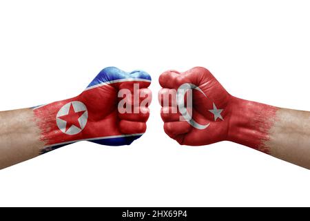 Two hands punch to each others on white background. Country flags painted fists, conflict crisis concept between north korea and turkey Stock Photo