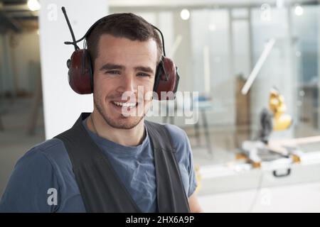 Hes committed to great contracting work. Handsome young contractor standing on a construction site. Stock Photo