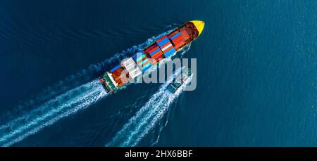 Container ship was dragged by tug boat to international cargo port for service transportation  ,logistic service transportation and maintenance concep Stock Photo