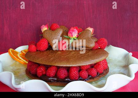 A giant chocolate macaron cake with fresh raspberries and rose flowers Stock Photo